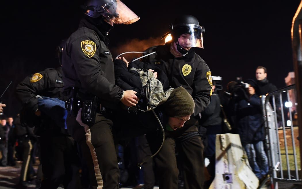Police arrest a protester in Ferguson, Missouri, during demonstrations a day after violent protests and looting following the grand jury decision.