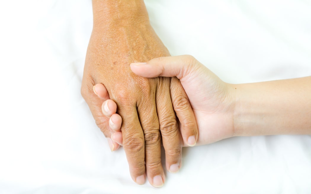 Asian senior and asian young holding hands.