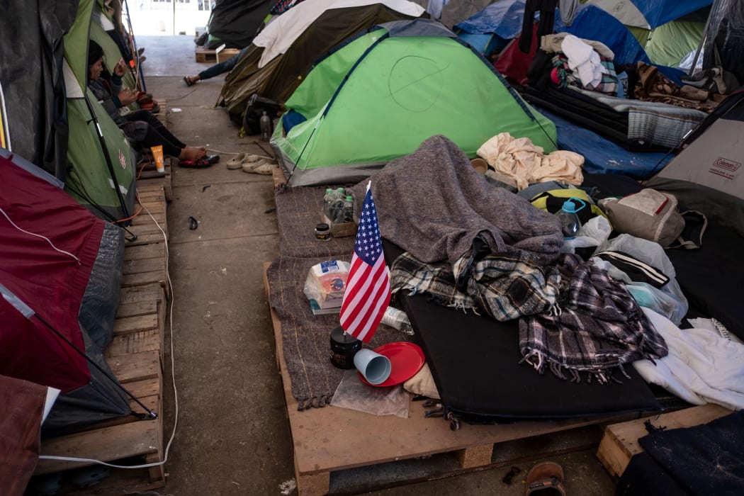 Central American migrant travelling in a caravan sits in her tent at El Barretal temporary shelter on the US-Mexico border in Tijuana, Baja California state, Mexico, on January 22, 2019.