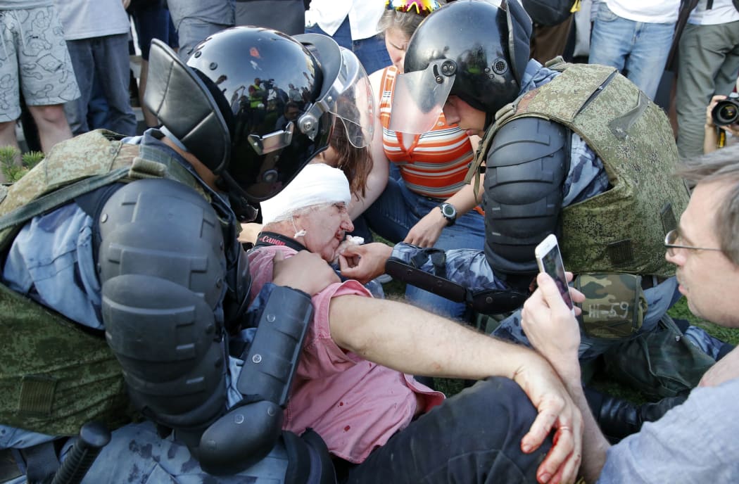 Servicemen of the Russian National Guard help an injured man during an unauthorised rally