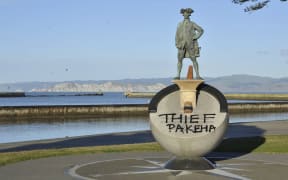 Graffiti on the statue of James Cook reading "Thief Pakeha".