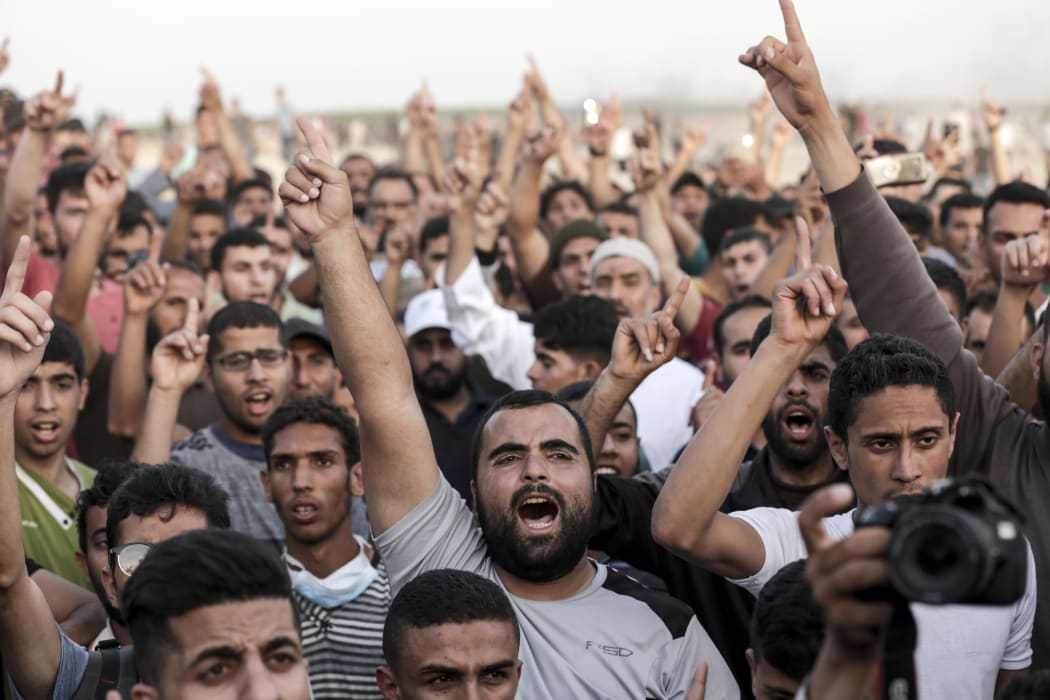 Palestinian demonstrators shout slogans during clashes with Israeli forces along the border with the Gaza strip east of Gaza city.