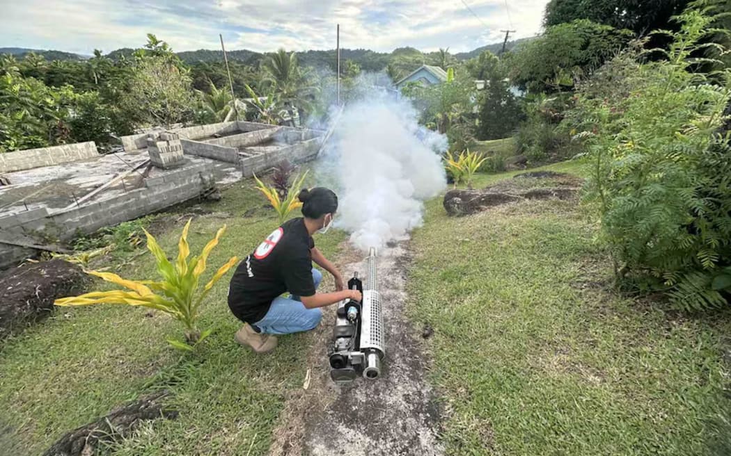 Environmental health officers in Fiji spray an area to prevent mosquitoes spreading dengue fever.