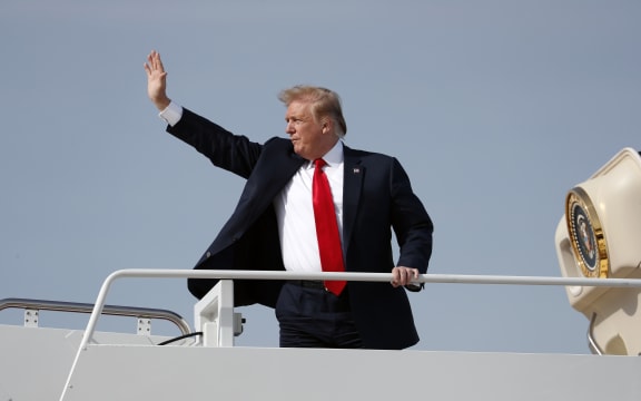President Donald Trump waves while boarding Air Force One.
