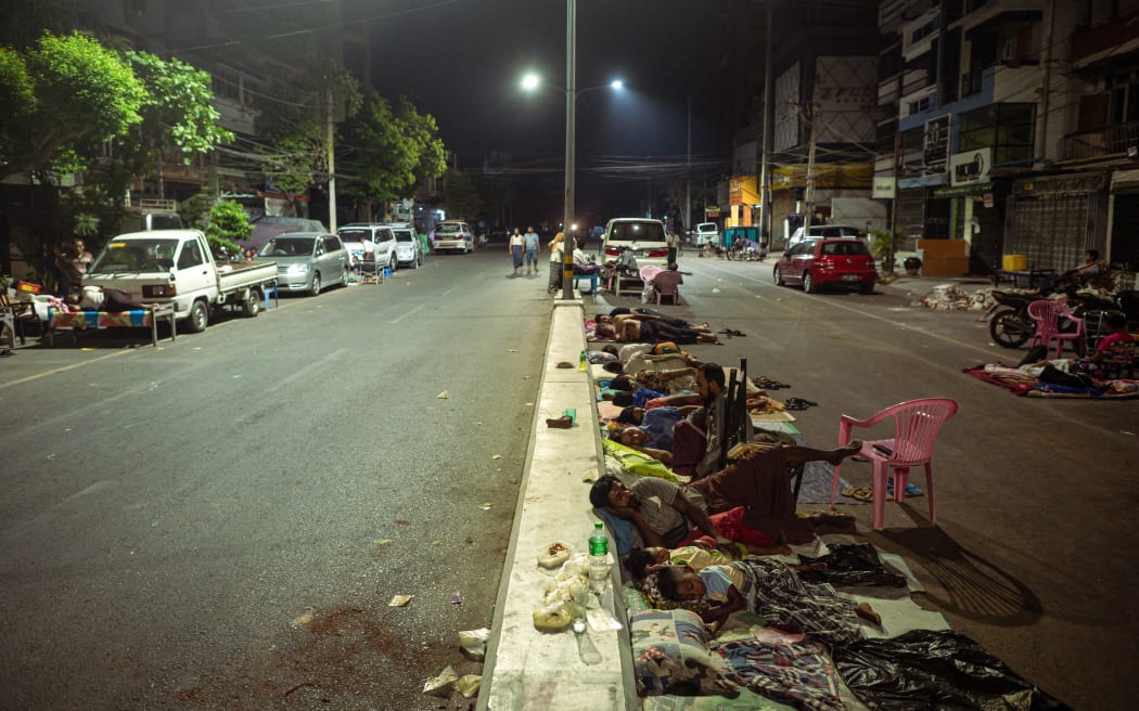 People sleep on the street in Mandalay on March 31, 2025 three days after the deadly Myanmar earthquake. Hopes were fading of finding more survivors in the rubble of Mandalay, where some residents spent a third night sleeping in the open after a massive earthquake killed at least 1,700 people in Myanmar and neighbouring Thailand. (Photo by Sai Aung MAIN / AFP)