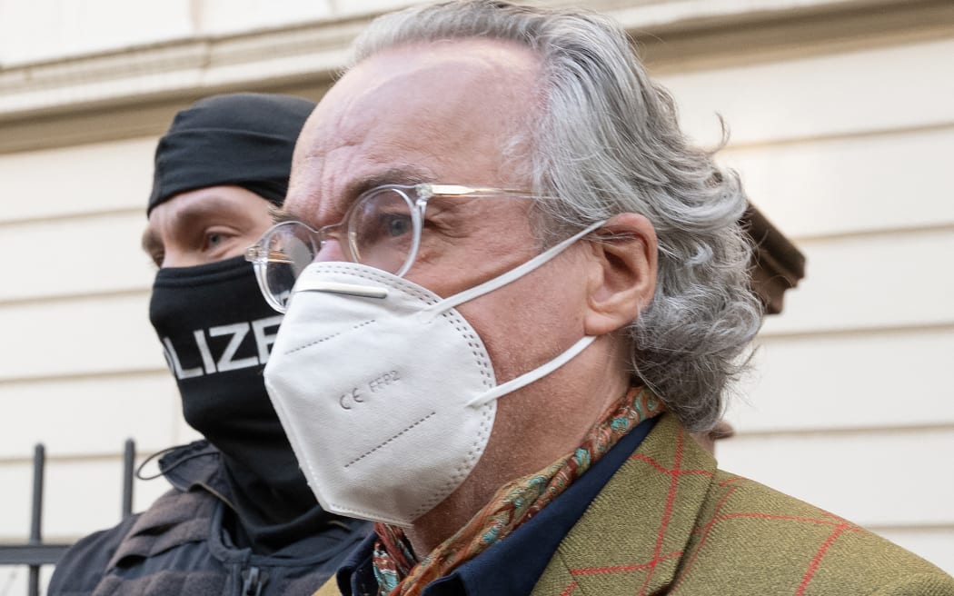 07 December 2022, Hessen, Frankfurt/Main: During a raid against so-called "Reich citizens", a masked police officer leads Heinrich XIII Prince Reuss (r) to a police vehicle after searching a house. The Federal Prosecutor's Office had several people from the so-called Reichsbürger scene arrested in the course of a raid on Wednesday morning. Numerous officers were on duty in several federal states, said a spokeswoman for the Karlsruhe authority . Photo: Boris Roessler/dpa (Photo by BORIS ROESSLER / DPA / dpa Picture-Alliance via AFP)