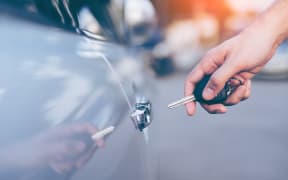 Men's hand using key unlock doors car