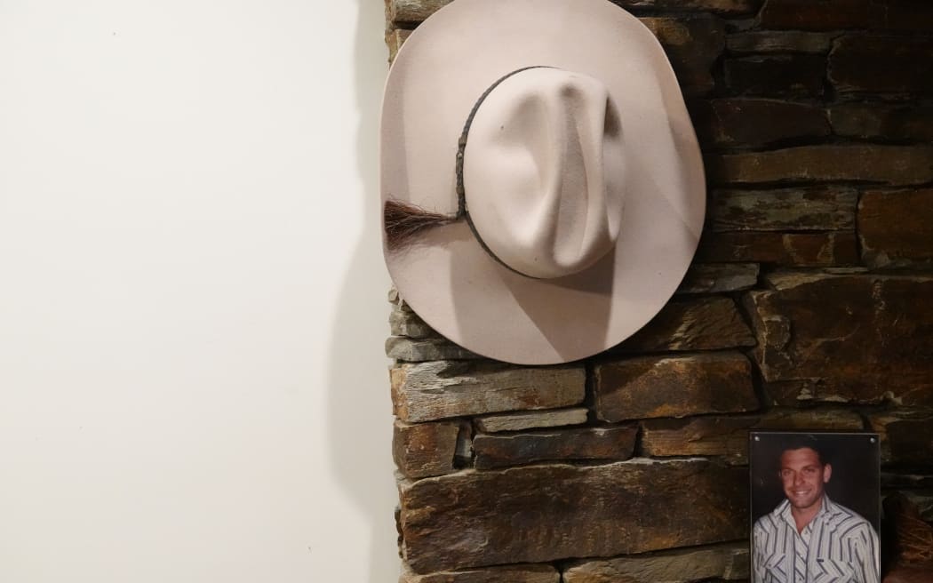 A cowboy hat belonging to Scott Guy hangs next to a picture of him in the Guy family home.