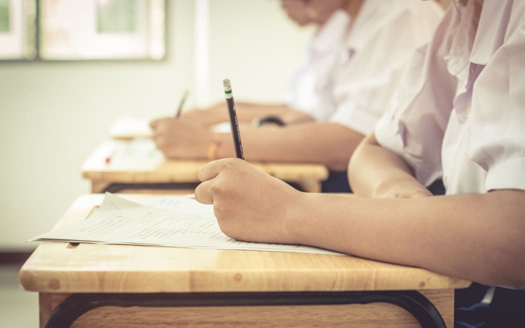 Asian girls students writing test exams on paper for Admissions in high school with uniform student in row seat School classroom of Thailand,