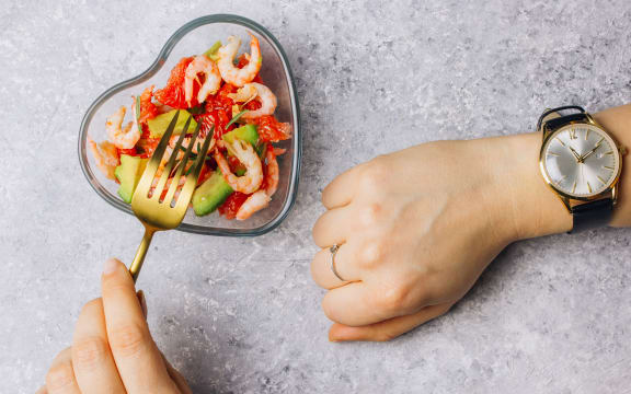 Intermittent fasting concept - countdown to eat salad with avocado, grapefruit and shrimps in bowl