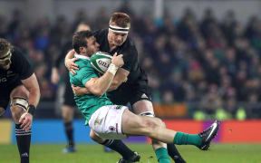 Ireland's Robbie Henshaw is injured in the tackle of Sam Cane of New Zealand