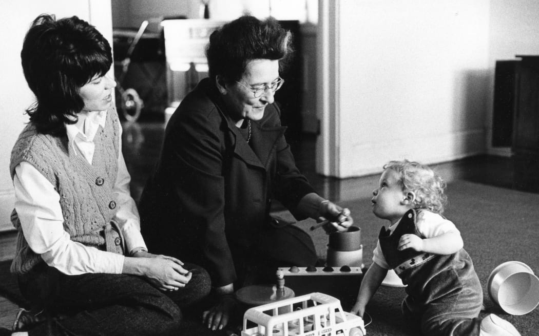 Mary Ainsworth playing with a child besides a woman in 1973.