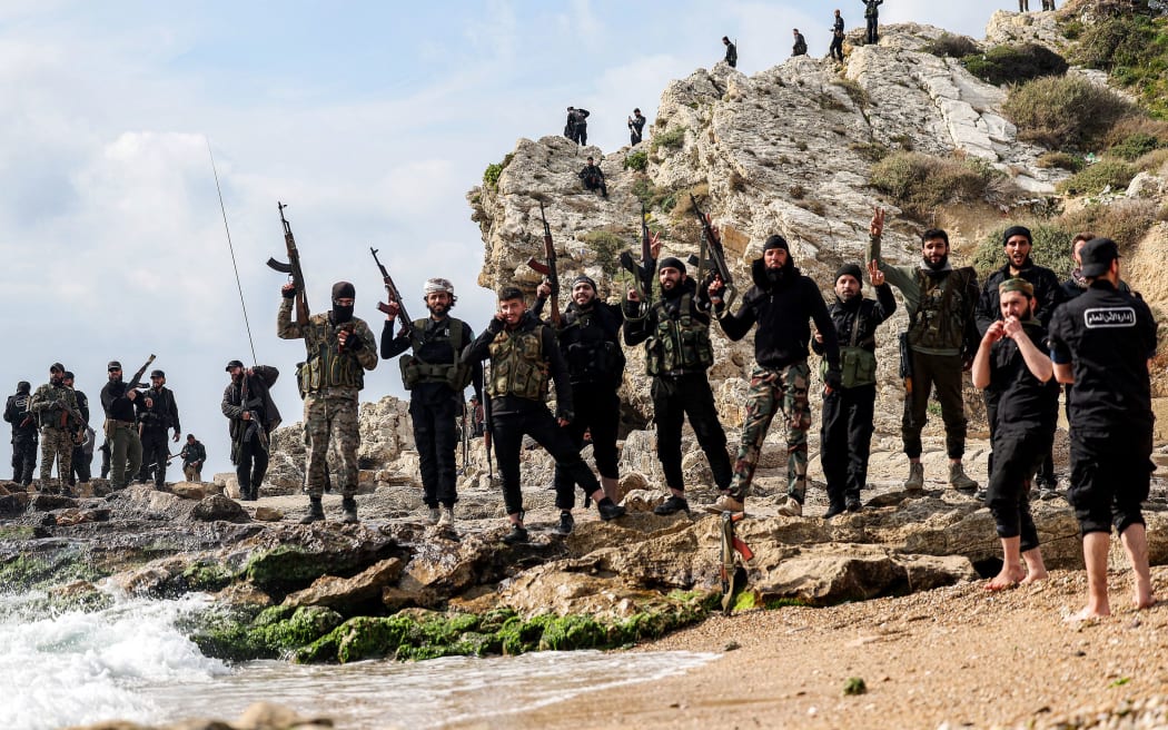 Members of security forces loyal to the interim Syrian government pose for a photo by the coast of the Mediterranean Sea in Latakia on March 9