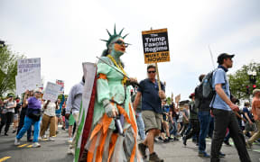 Protestors hold signs as they march towards the White House during a Free Kilmar Abrego and an Anti-Trump protest, in Washington, DC, April 19, 2025. Abrego Garcia was detained in Maryland last month and expelled to El Salvador along with 238 Venezuelans and 22 fellow Salvadorans who were deported shortly after President Donald Trump invoked a rarely-used wartime authority. 
Trump administration officials have claimed he is an illegal migrant, a gang member and involved in human trafficking, without providing evidence. 
A federal judge has since ordered he be returned, later backed up by the Supreme Court.
But the administration -- despite admitting an "administrative error" in his deportation -- contends he is now solely in Salvadoran custody. (Photo by Richard PIERRIN / AFP)