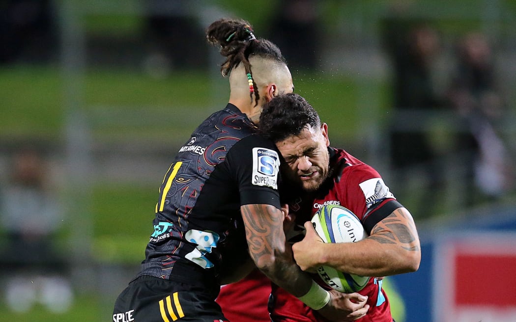 Chiefs winger Sean Wainui tackles Crusaders captain Codie Taylor.