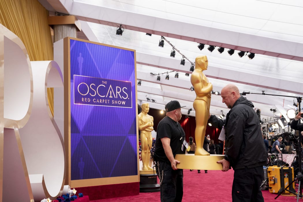 Workers carry an Oscar statue on the red carpet near the Dolby Theater, Los Angeles, ahead of the 94th Academy Awards.