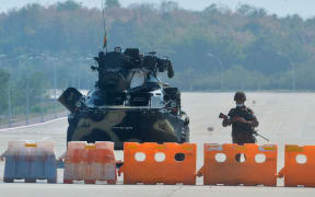 A soldier stands guard on a blockaded road to Myanmar's parliament in Naypyidaw on 1 February 2021, after the military seized power in a coup against the elected government of NLD leader Aung San Suu Kyi.