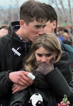 FILE - In this April 25, 1999 file photo, shooting victim Austin Eubanks hugs his girlfriend during a community wide memorial service in Littleton, Colo., for the victims of the shooting rampage at Columbine High School the previous week.
