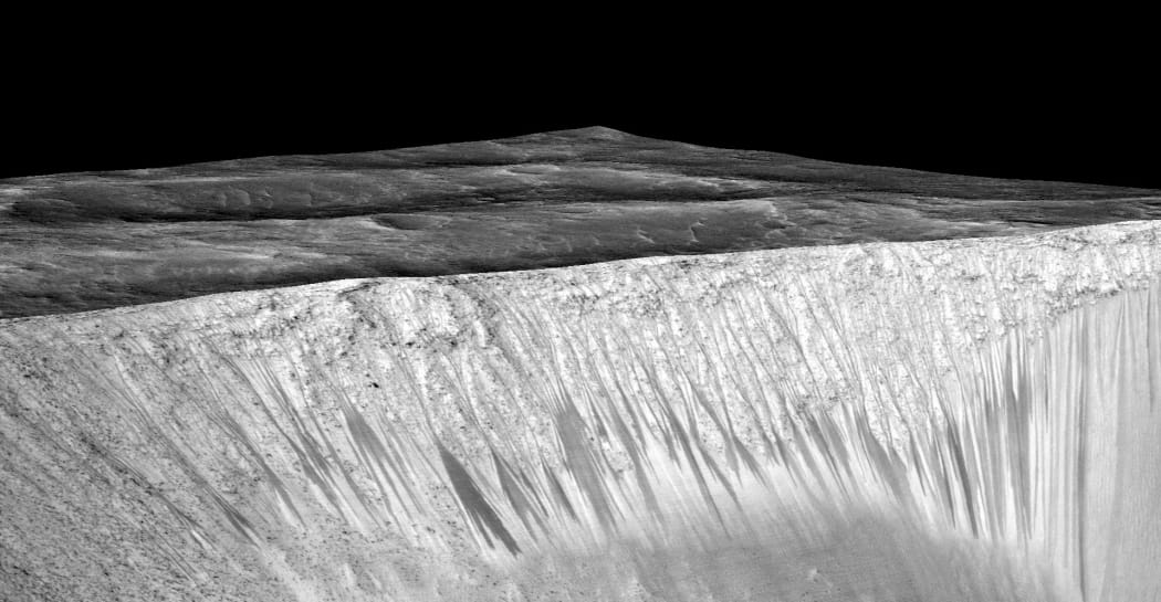 The dark streaks on the walls of Garni crater are hypothesized to be formed by flow of briny liquid water. The image is produced by draping an orthorectified image on a Digital Terrain Model (DTM) of the site.