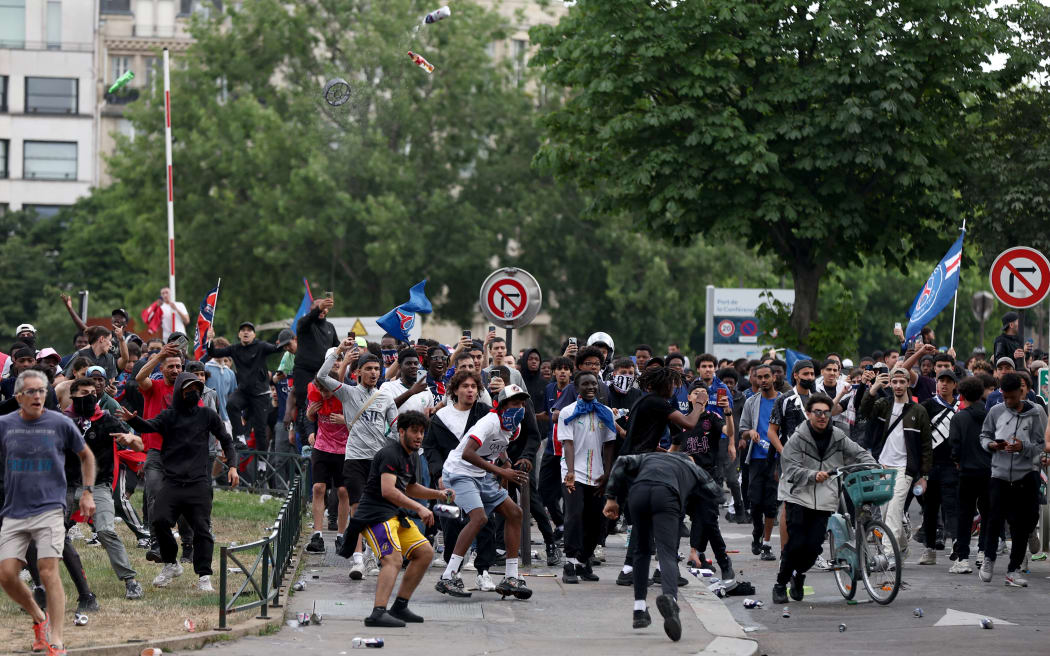 Crowd clashes with police officers following the PSG team bus parade, near the Champs-Elysees avenue in Paris on June 1, 2025, a day after PSG won the 2025 UEFA Champions League final football match against Inter Milan in Munich. (Photo by Romain PERROCHEAU / AFP)