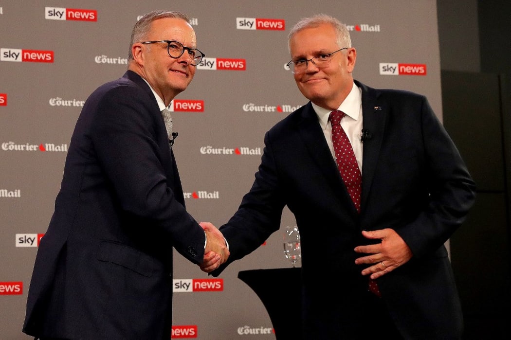 Australian Prime Minister Scott Morrison (R) shakes hands with leader of the opposition, Anthony Albanese, during the first leaders' debate of the 2022 federal election campaign at the Gabba in Brisbane on April 20, 2022.
