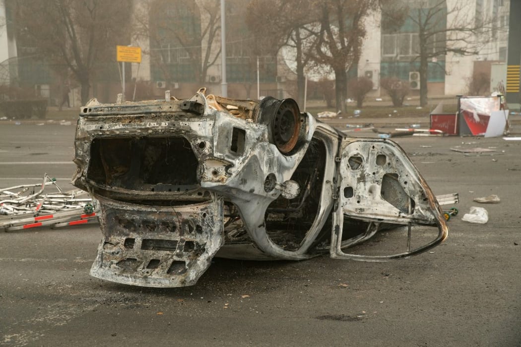 A burned-out automobile is seen on a square near an administrative quarter in central Almaty on January 6, 2022. -