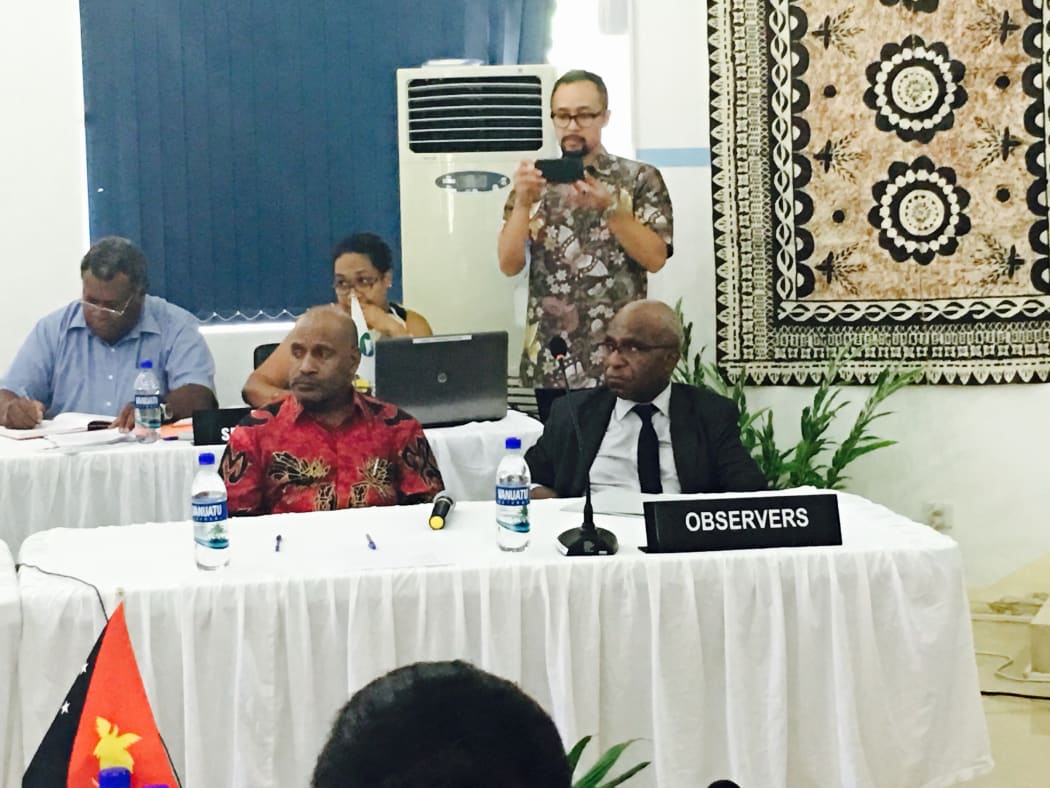 An Indonesian captures the Melanesian Spearhead Group proceedings, 20 December 2016 in Port Vila, on device. West Papuan representatives Benny Wenda and Octo Mote (MSG observers with the United Liberation Movement) in foreground.