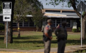 Officers stand outside Robb Elementary School in Uvalde, Texas, on May 25, 2022 where children and teachers were killed in a shooting.