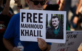 Protesters gather at Ervan Chew Park in Houston, Texas, on June 8, 2025, for a demonstration against Trump's immigration policies and mass deportations. A protester holds a sign that reads, ''Free Mahmoud Khalil.'' (Photo by Reginald Mathalone/NurPhoto) (Photo by Reginald Mathalone / NurPhoto via AFP)