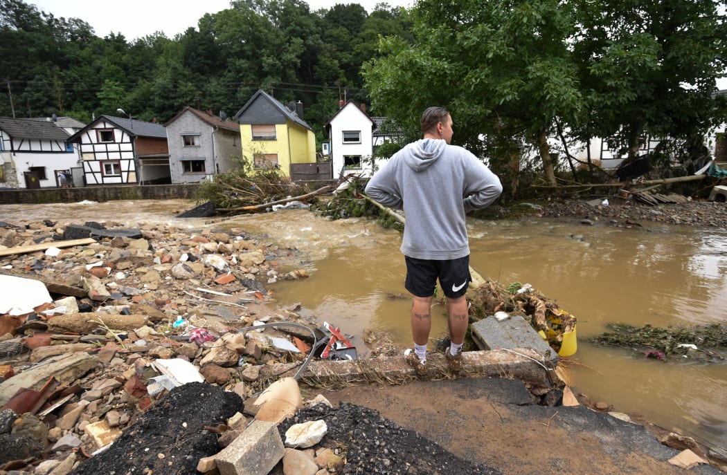 A man standing at a flooded intersection near the Erft river in Iversheim near Bad Muenstereifel, western Germany.