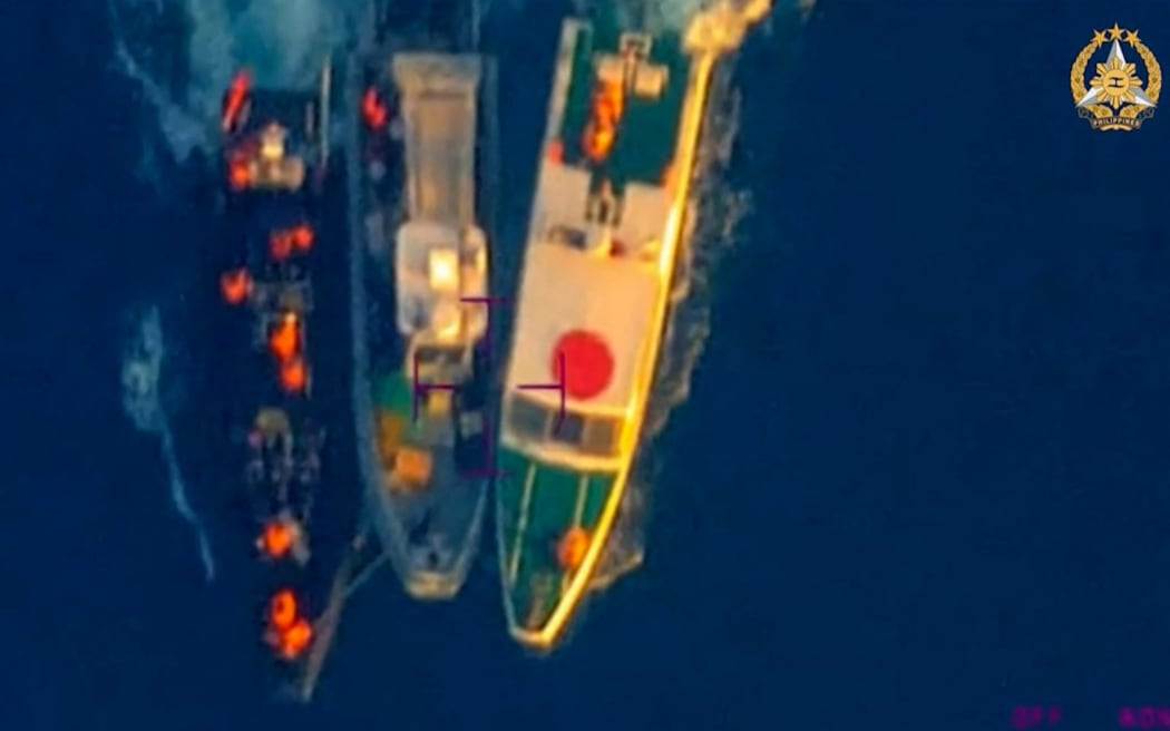 This frame grab from handout video taken on June 17, 2024 and released by the Armed Forces of the Philippines Public Affairs Office on June 19 shows an aerial view of a Philippine Rigid Hull Inflatable Boat (RHIB) (C) between two China coast guard vessels during an incident off Second Thomas Shoal in the South China Sea. The Philippine military said on June 19 the Chinese coast guard rammed and boarded Filipino navy boats in a violent confrontation in the South China Sea this week in which a Filipino sailor lost a thumb. China defended its actions, with its foreign ministry saying on Wednesday that "no direct measures" were taken against Filipino personnel. (Photo by Handout / ARMED FORCES OF THE PHILIPPINES-PUBLIC AFFAIRS OFFICE / AFP) / -----EDITORS NOTE --- RESTRICTED TO EDITORIAL USE - MANDATORY CREDIT "AFP PHOTO / ARMED FORCES OF THE PHILIPPINES - PUBLIC AFFAIRS OFFICE" - NO MARKETING - NO ADVERTISING CAMPAIGNS - DISTRIBUTED AS A SERVICE TO CLIENTS