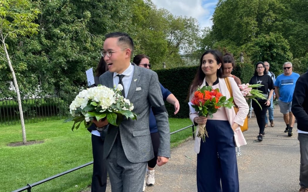 New Zealand Society UK president Clarence Tan arrives with his floral tribute.