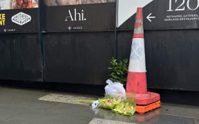 Flowers laid outside the barriers of the construction site, on 21 July 2023, the day after the shootings.