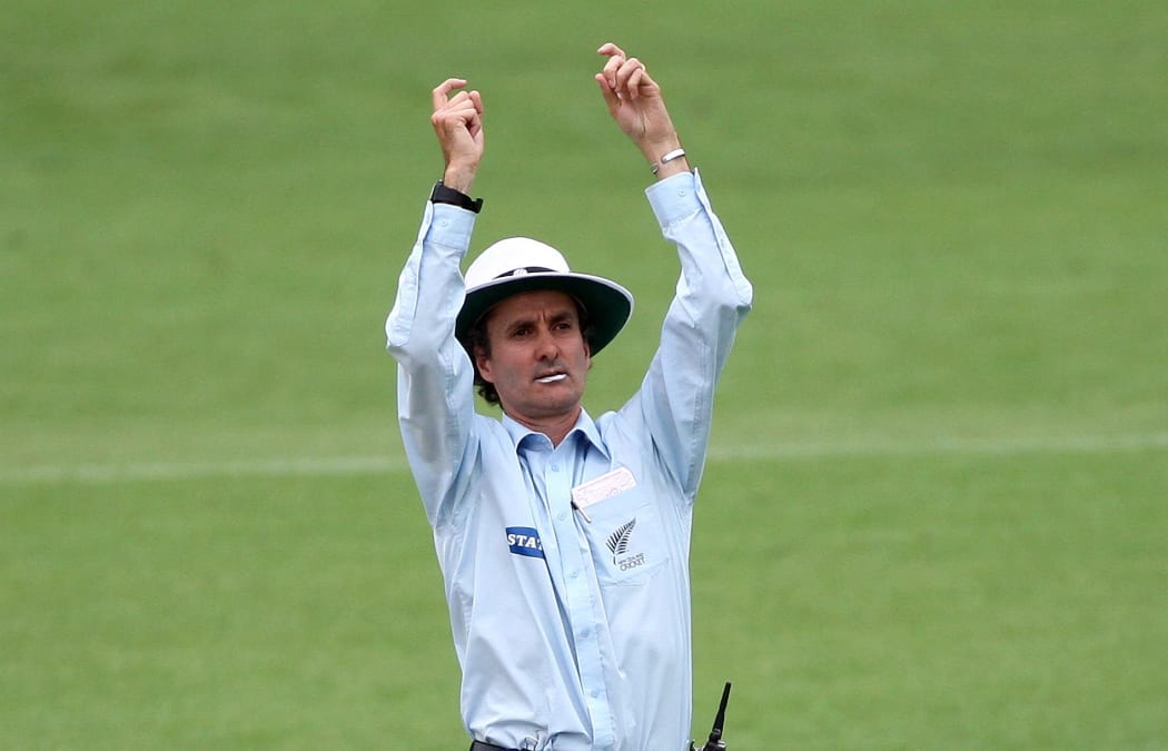 New Zealand cricket umpire Billy Bowden signals a six.