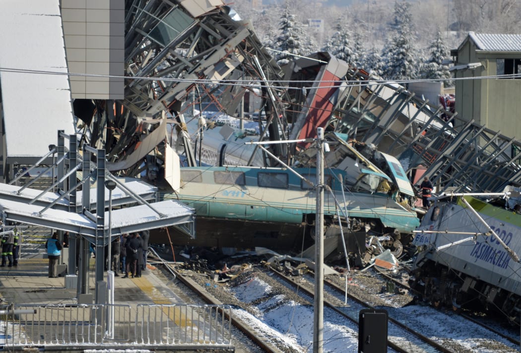 A rescue worker stands on the wreckage after a high speed train crash in the Turkish capital Ankara, Turkey. A high speed train hit a railway engine and crashed into a pedestrian overpass. Altan Gocher / Sputnik