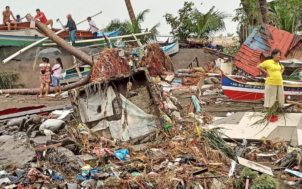 Residents surveying damage caused by heavy rain and floods in Oroquieta City.