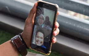 A man video calls his family on his cell phone.