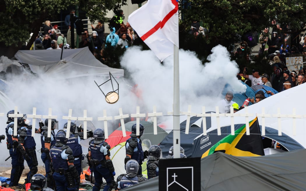 A bar stool flies at police through the mist from a fire extinquisher