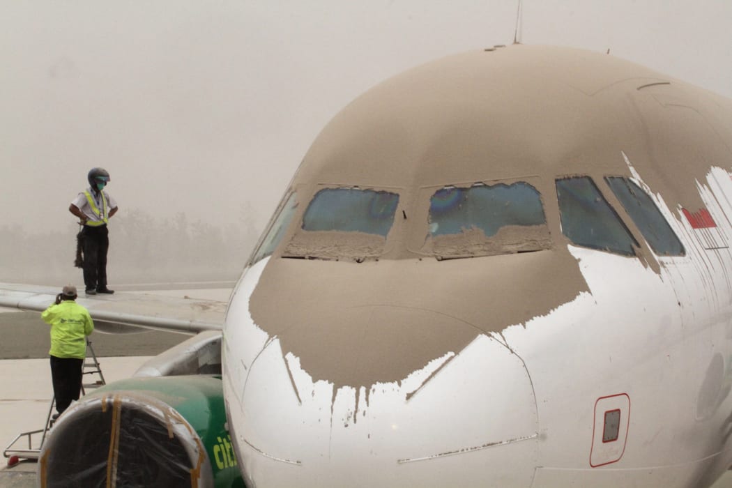 Airport personnel inspect an ash-covered plane at Yogyakarta airport, about 200km west of Mt Kelud.