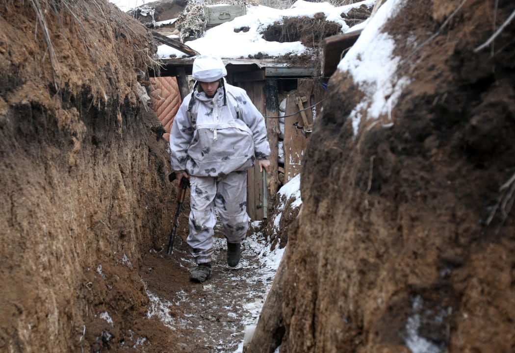 A Ukrainian serviceman walks along a snow covered trench on the front line with the Russia-backed separatists near Verkhnetoretskoye, in the Donetsk region on 1 February 2022.