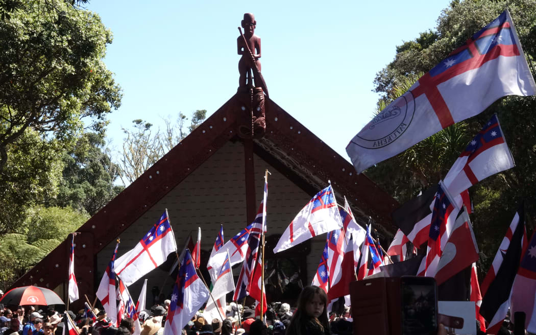 The hīkoi arrives at Te Whare Rūnanga (the carved meeting house) at the Treaty Grounds.