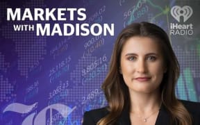 The podcast tile graphic for Markets with Madison. Madison smiles coolly at the camera, wearing a black blazer. Behind her is a stylised purple background with market figures.