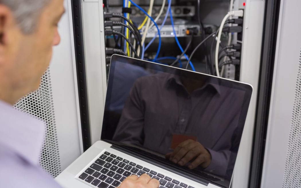 Stock image of an IT worker doing maintenance at a data centre.