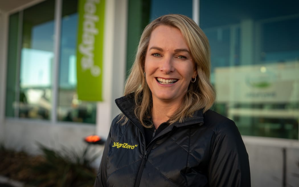 Ruth Leary is a blond lady. She is smiling, wearing and AgriZeroNZ puffer jacket.