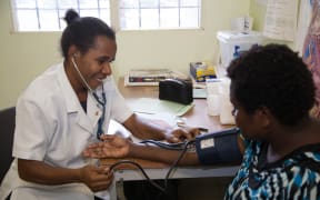 Rose (mother) and toddler in the treatment room at Susa Mama health clinic, Port Moresby General Hospital, PNG