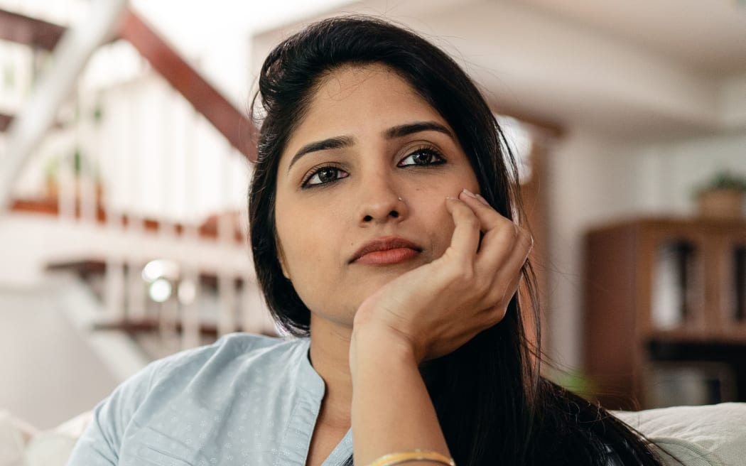 Woman of Indian appearance looking thoughtful