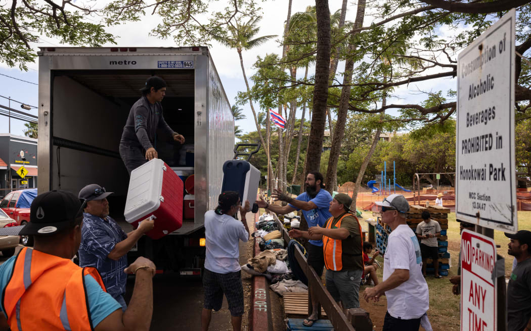 Volunteers unload ice and cooler donations at a distribution center for those affected by the Maui fires at Honokawai Beach Park in Napili-Honokowai, west of Maui, Hawaii, 14 August, 2023.