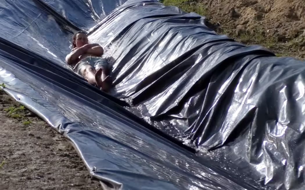 Max Humpherson going down the Ōhope Beach waterslide.