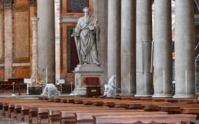 Men clean the floor and surfaces of the churchyard of the Basilica of Saint Paul Outside The Walls in Rome, on 16 May.