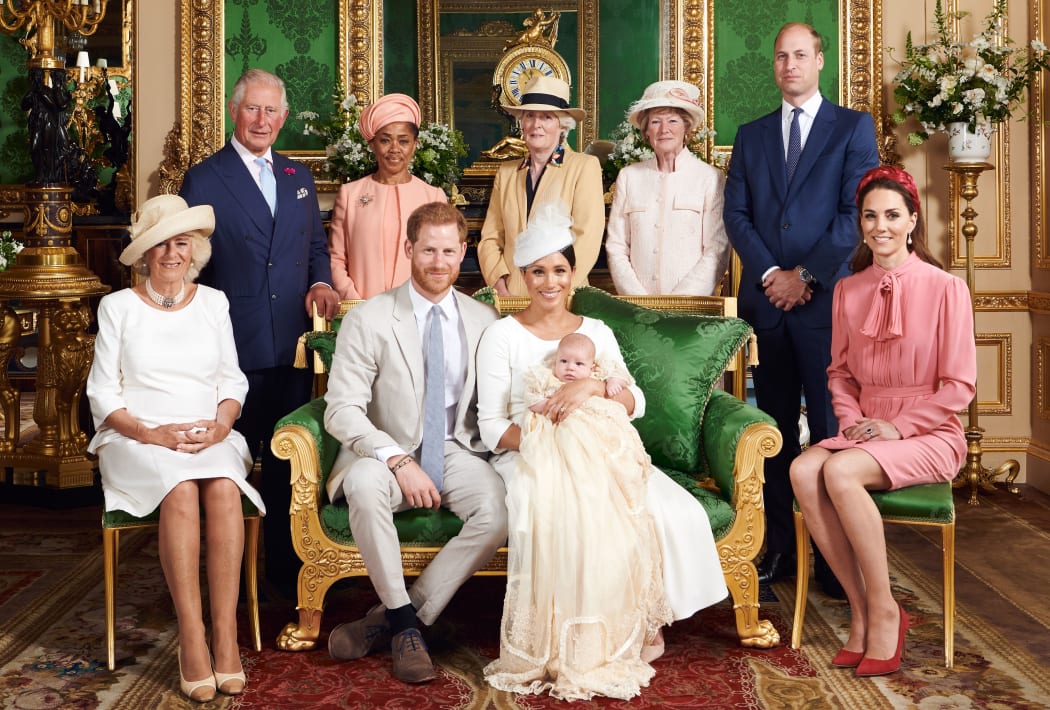 This official handout Christening photograph released by the Duke and Duchess of Sussex shows Britain's Prince Harry, Duke of Sussex (centre left), and his wife Meghan, Duchess of Sussex holding their baby son, Archie Harrison Mountbatten-Windsor